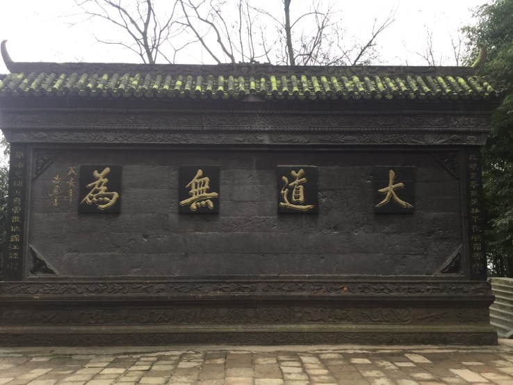 You have to read the words from right to left. The phrase was written in traditional Chinese, and it means the greatest virtue is to do nothing (my own translation haha). It is central to Daoism in China. 